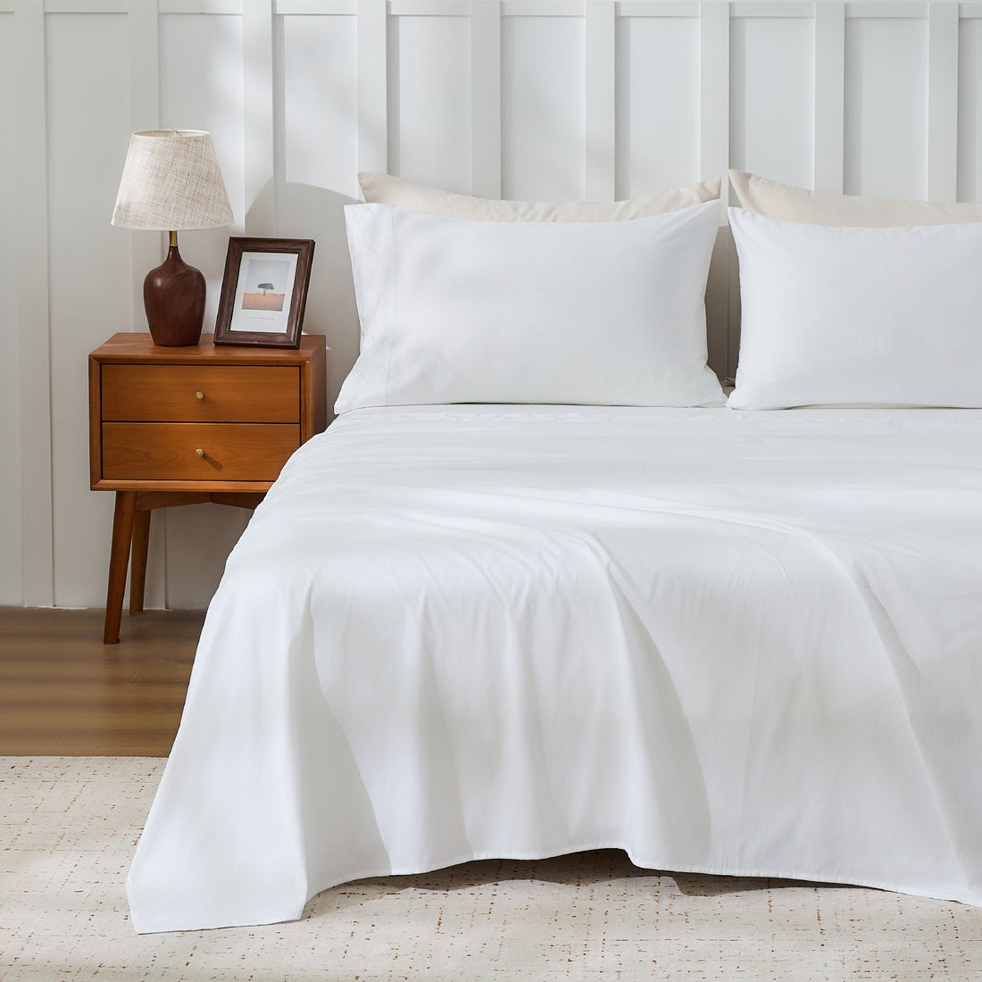 Litanika crisp percale organic cotton sheet set with neatly folded bedding, showcasing smooth, breathable fabric for comfortable sleep.