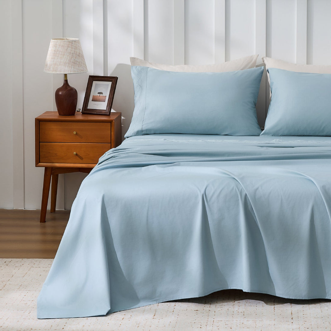 Litanika crisp percale organic cotton sheet set with neatly folded bedding, showcasing smooth, breathable fabric for comfortable sleep.