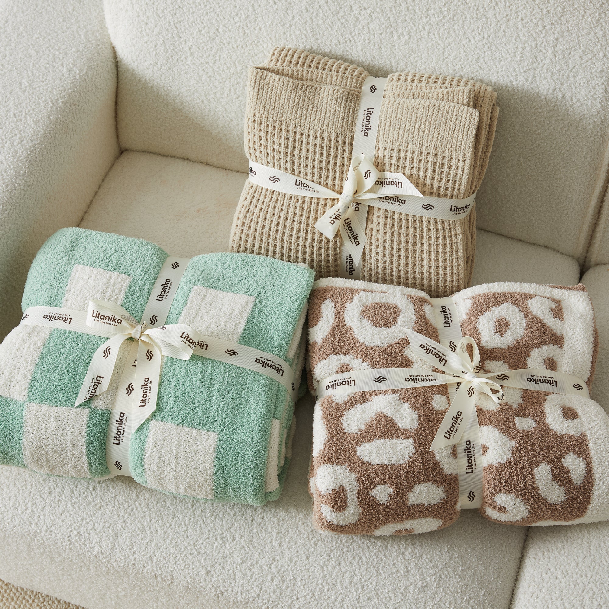 Litanika soft cozy cable knit throw blanket in neutral color, perfect for bedding and adding warmth to a bed or couch.