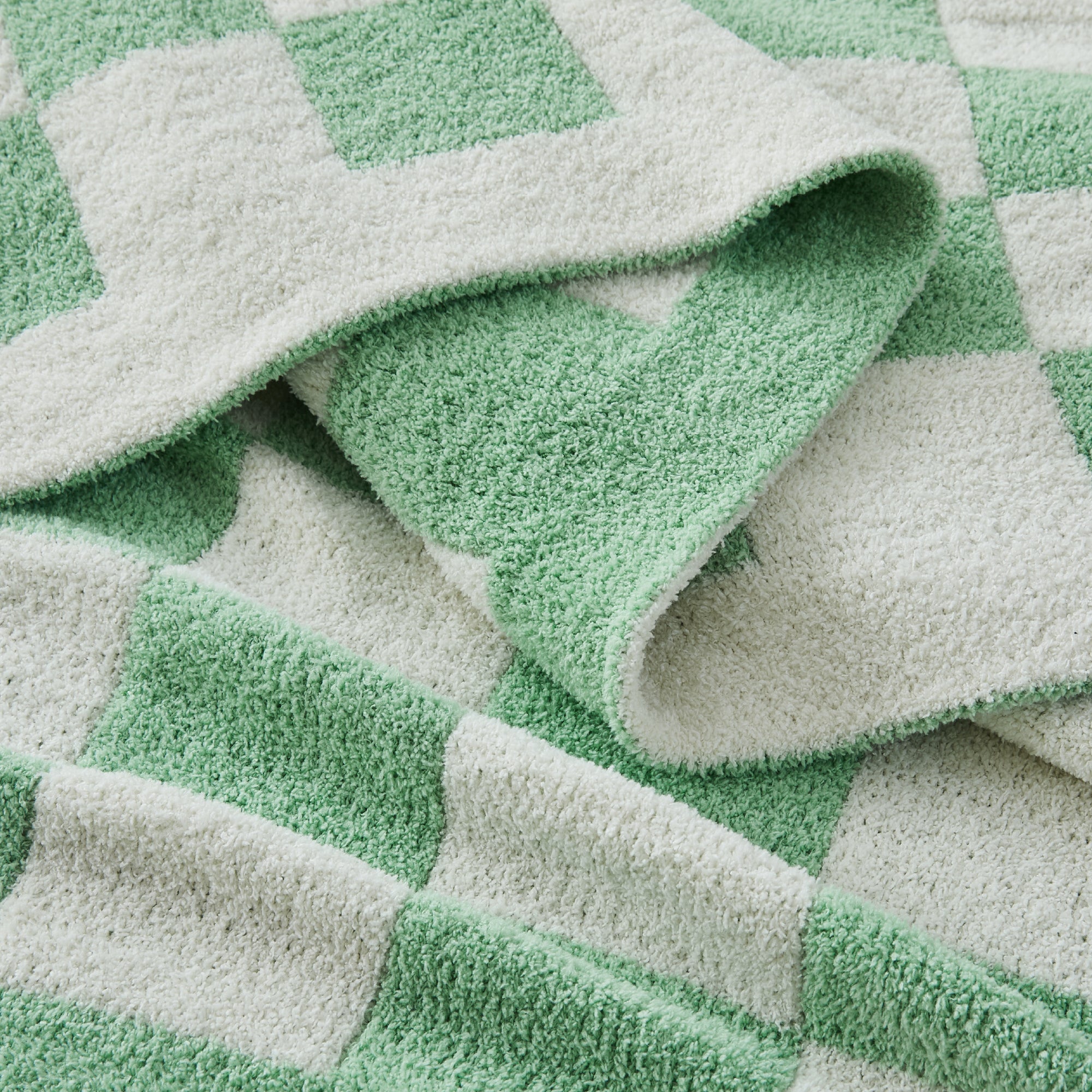 Litanika soft knit checkered throw blanket spread on a bed, cozy bedding accessory with a classic checkered pattern.